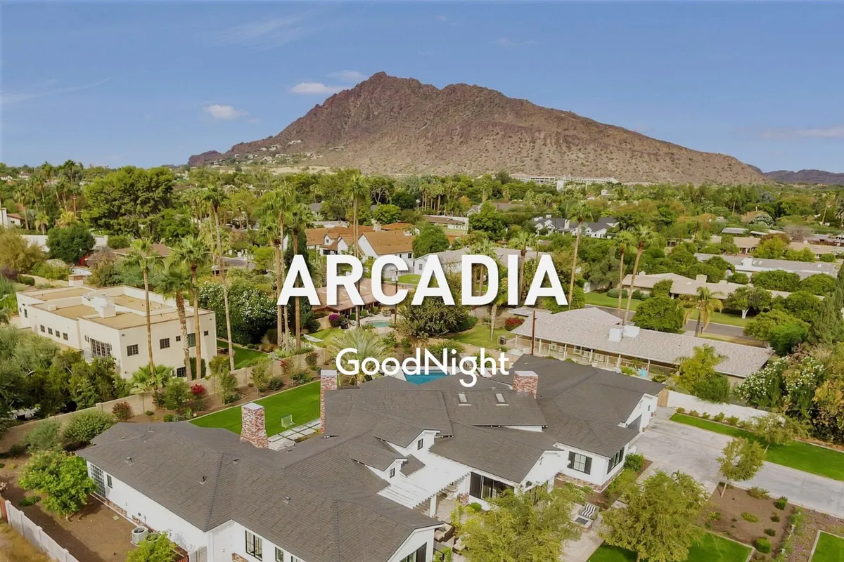 The exterior of the property framed by a mountain backdrop, lush greenery, and a spacious yard. The setting is tranquil and inviting, perfect for outdoor gatherings, gardening, or simply relaxing in the fresh air with architectural details hinting at the luxury within.
