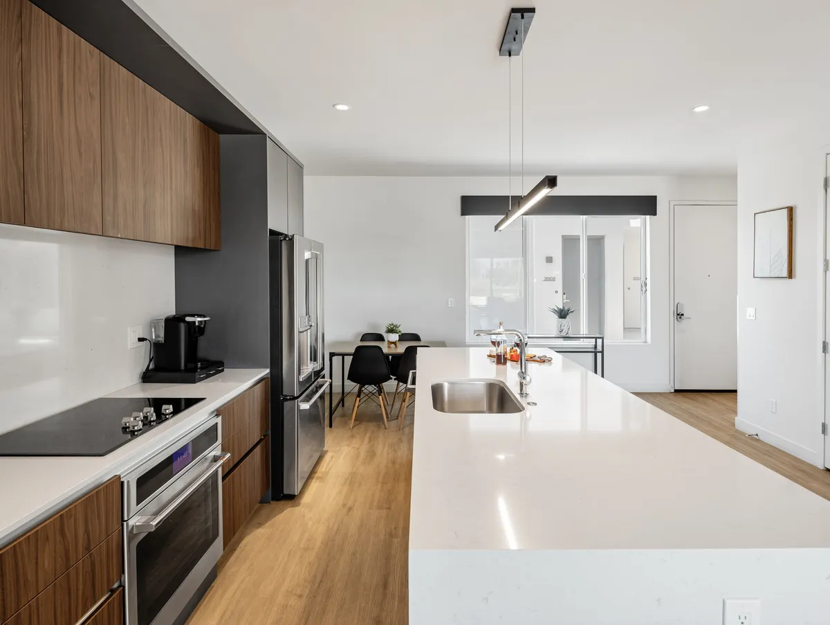 A welcoming, functional kitchen with a central island, stainless steel appliances, wood cabinetry, and a cozy dining area. The space invites both cooking and socializing.