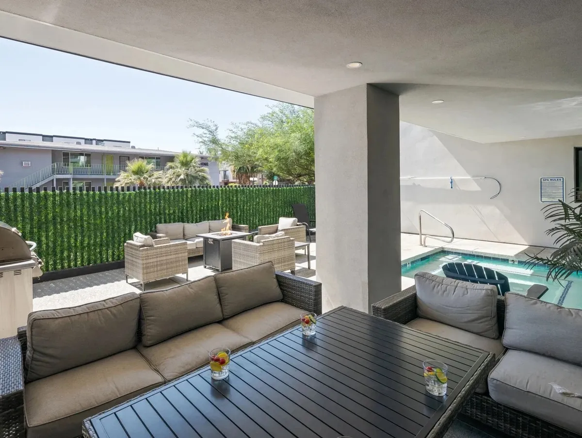 A welcoming outdoor scene featuring comfortable seating around a sparkling swimming pool, surrounded by lush greenery. The relaxed arrangement invites guests to gather for socializing, outdoor meals, or quiet moments by the water, all with the backdrop of a beautifully landscaped environment.